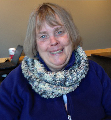 Linda sporting the colorful scarf she knitted (photo by Peter Langmaid)