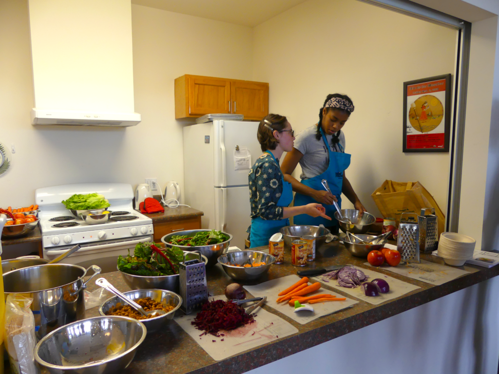 Two youth educators prep food.