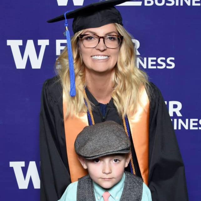 A blonde woman with glasses with her young son at her University of WA graduation