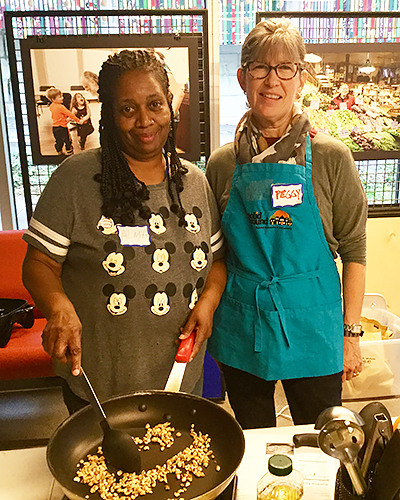 (L to r): Alma Britton and Peggy Keene toast walnuts for pesto in a Cooking Matters class.