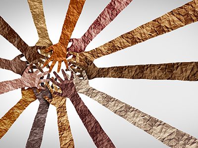 A sunburst of arms made out of crinkled paper in multi-shades of brown.