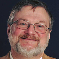 A smiling man with a beard and glasses.