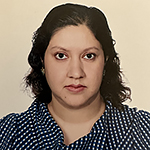 Headshot of a woman with dark hair wearing a checked blouse.