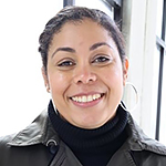 Headshot of a smiling woman with dark hair wearing a black turtleneck and black leather jacket.