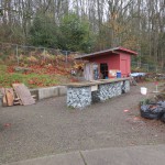 A before shot of the Seattle Community Farm work tables and toolshed. The pink markers on the ground indicate the locations of the support posts for the canopy.