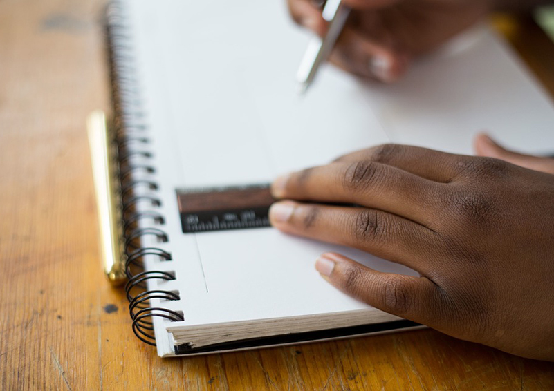 Student hand with notepad & ruler