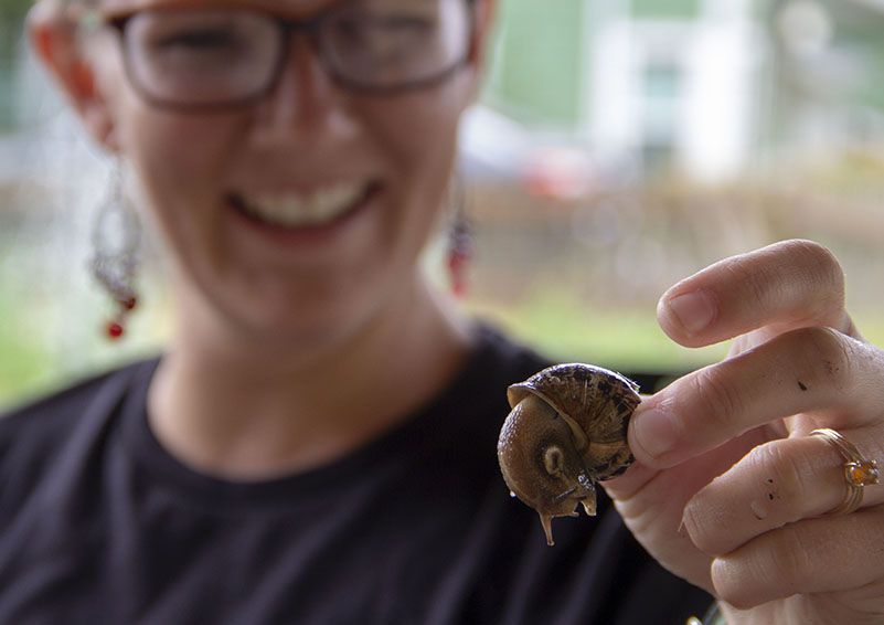 Volunteer and recent University of Washington graduate Makenzie Graham smiles for a photo with a garden resident.