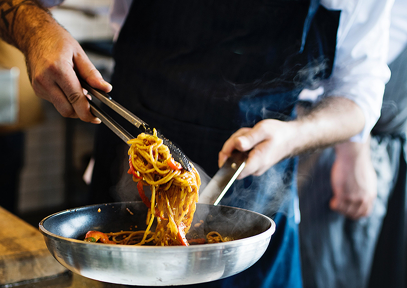 Chef stir frying noodles