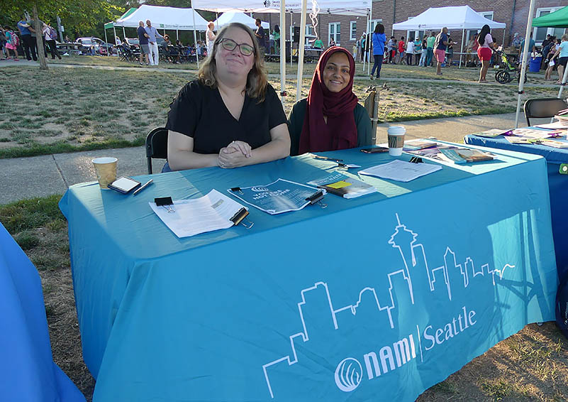 Two women sit at the NAMI Seattle table
