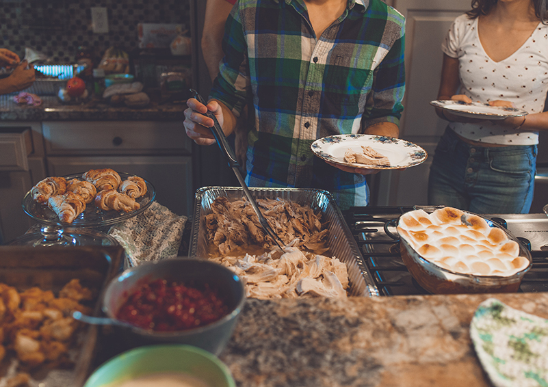 People filling plates at a holiday meal buffet