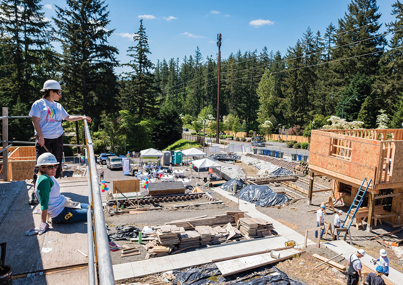 Two women construction workers looking over a Habitat for Humanity build site. 