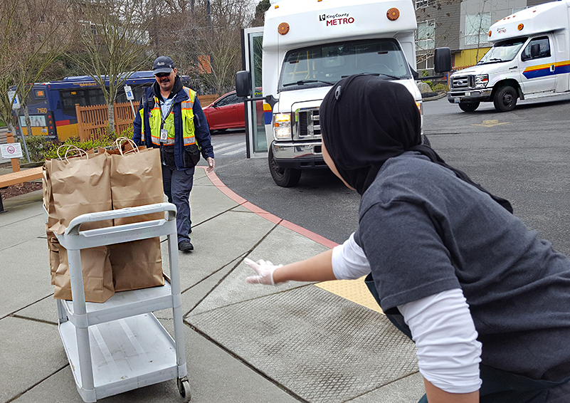 Access bus driver with cart carrying bags of food