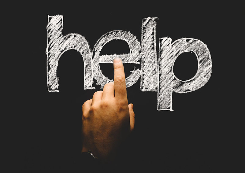 help written in block letters on a blackboard, with a hand poised to tap it like it's a computer screen