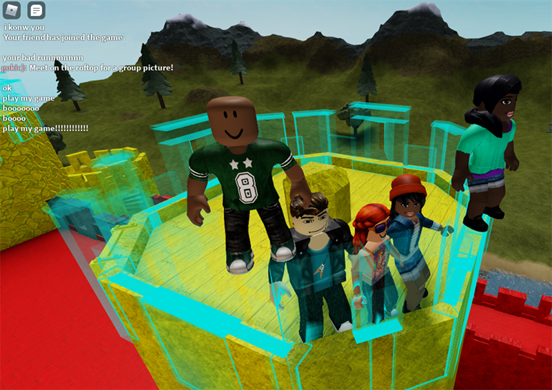 Screenshot of five video game youth characters standing atop a yellow castle turret with a mountain range in the background