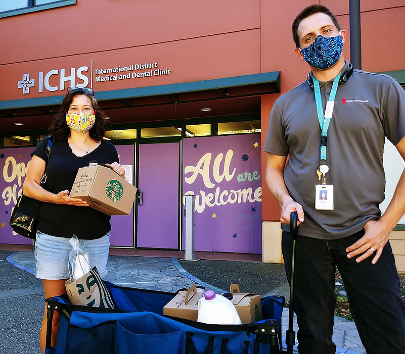 Two ICHS healthcare workers holding the donated Starbucks coffee
