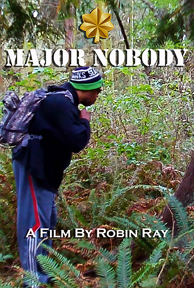 Movie title page for MAJOR NOBODY, A FILM BY ROBIN RAY. Robin is in the woodswearing a Seahawks cap, navy hoodie, dark sunglasses, and a purple backpack.