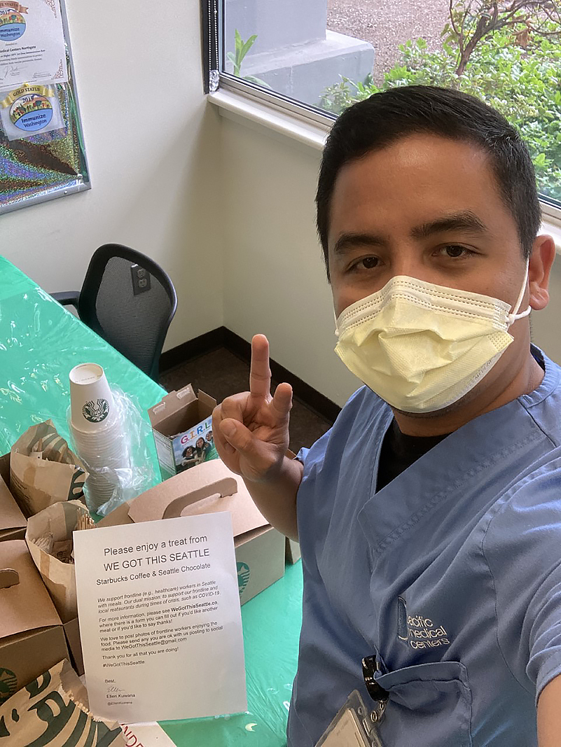 A healthcare worker with peace sign and donated coffee