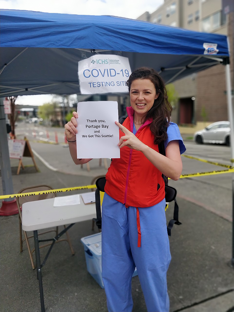 A healthcare worker with the thank you sign