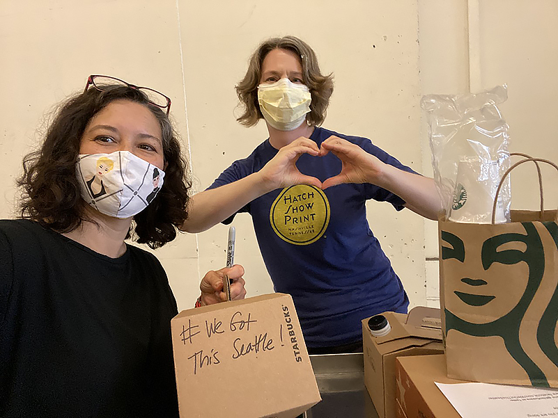 Two healthcare workers with love sign