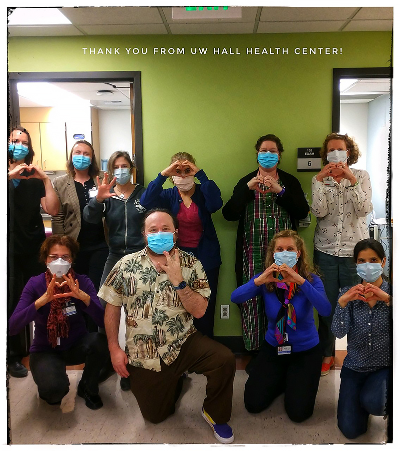A group of healthcare workers with love signwith the