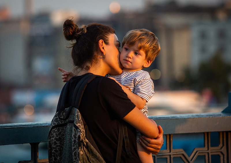 A mother kissing her child