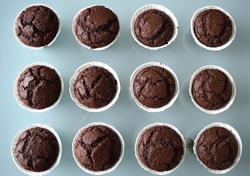 12 chocolate cupcakes on a light-blue counter