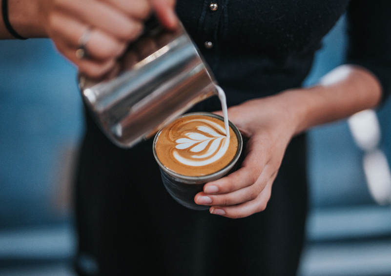 A barista pouring a latte