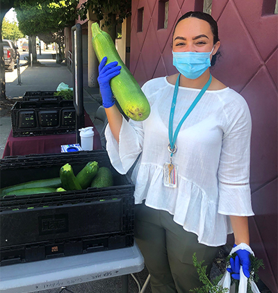 A woman holding a large zuchinni