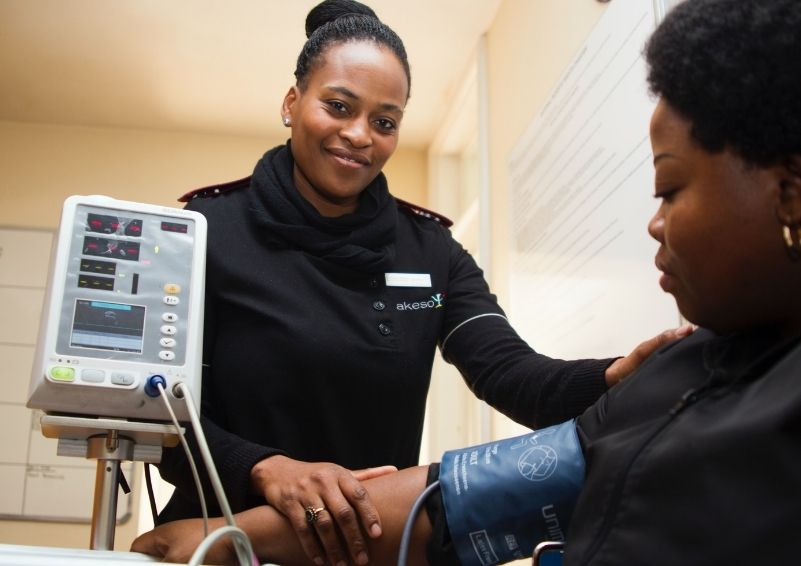 A nurse checking a patients blood pressure.
