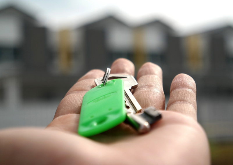 A set of house keys in the palm of an out-stretched hand