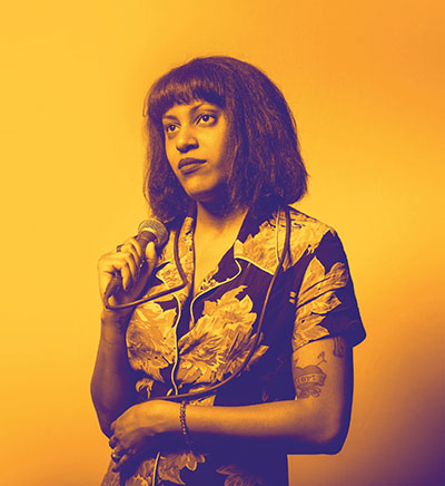 Woman with dark hair in a floral shirt holding a microphone, colorized in purple with a gold background