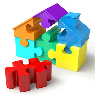 House made of bright puzzle pieces (purple, orange, blue, aqua, green and yellow) with one missing piece, a red one, in the foreground