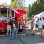 Customers line up at red food truck.