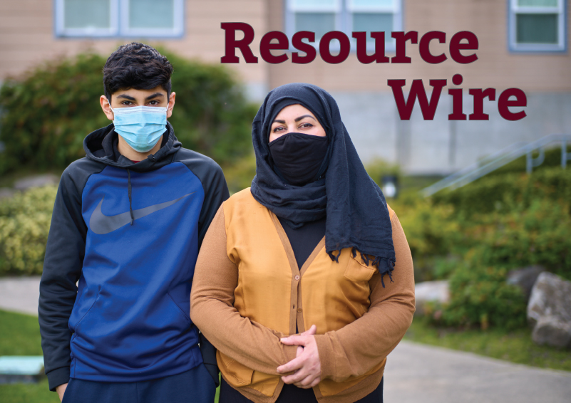 A woman with a head scarf stands beside her son, wearing a blue sweater. An apartment building can be seen in the background and the words "Resource Wire" appears beside them.