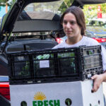 A volunteer brings boxes of vegetables in to the clinic.