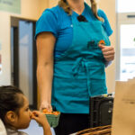 Sarah Benson offers a carton of cherry tomatoes for a child to sample.