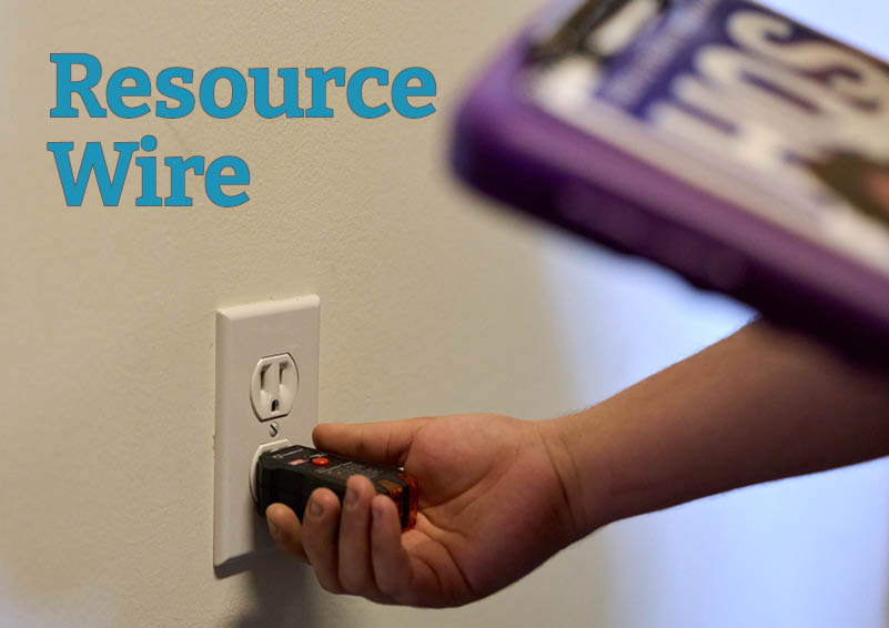 A close-up shot of a hand plugging a testing device into an electrical outlet. The words "Resource Wire" appear in the corner.
